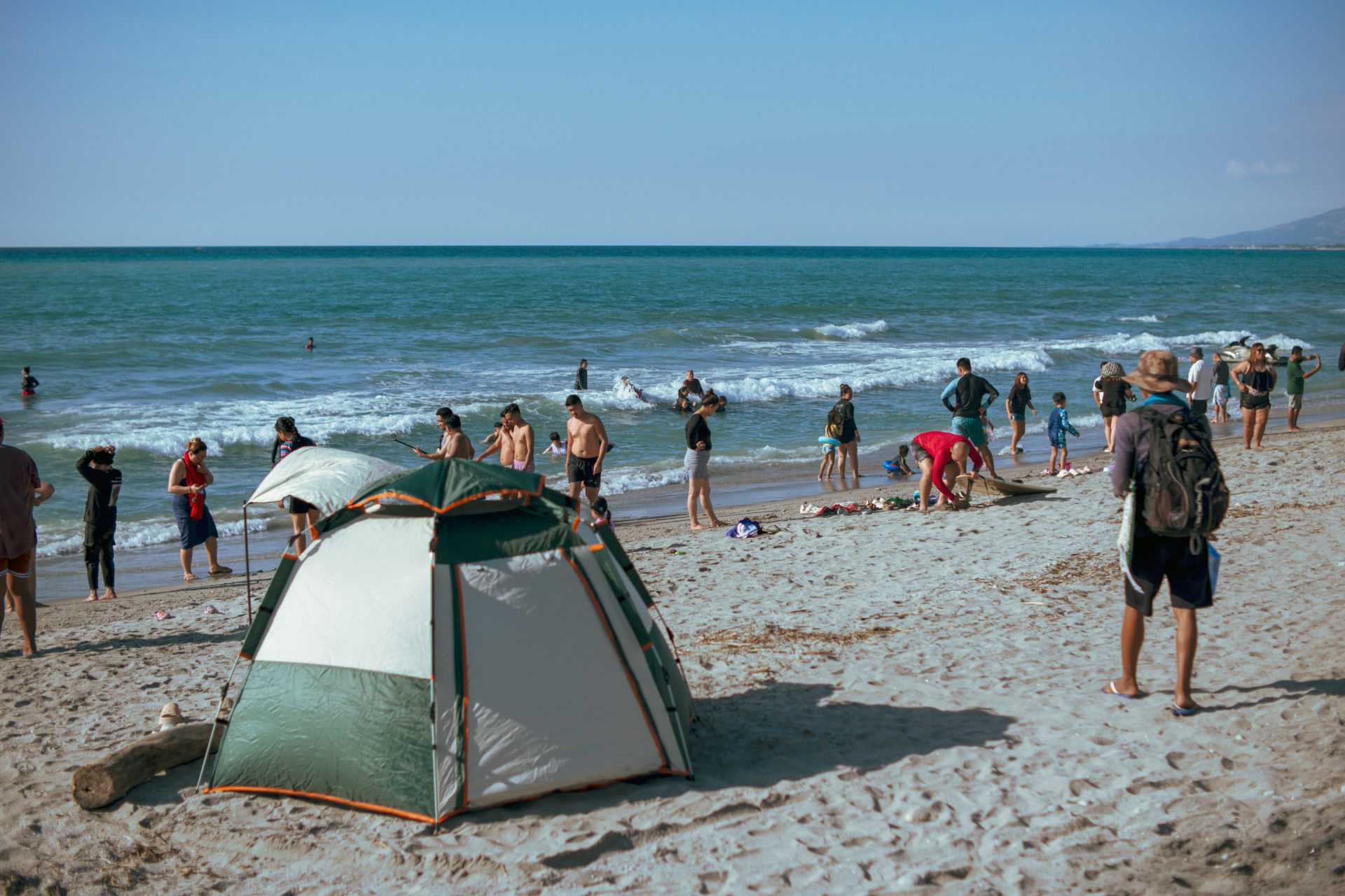 A group of people standing on top of a sandy beach